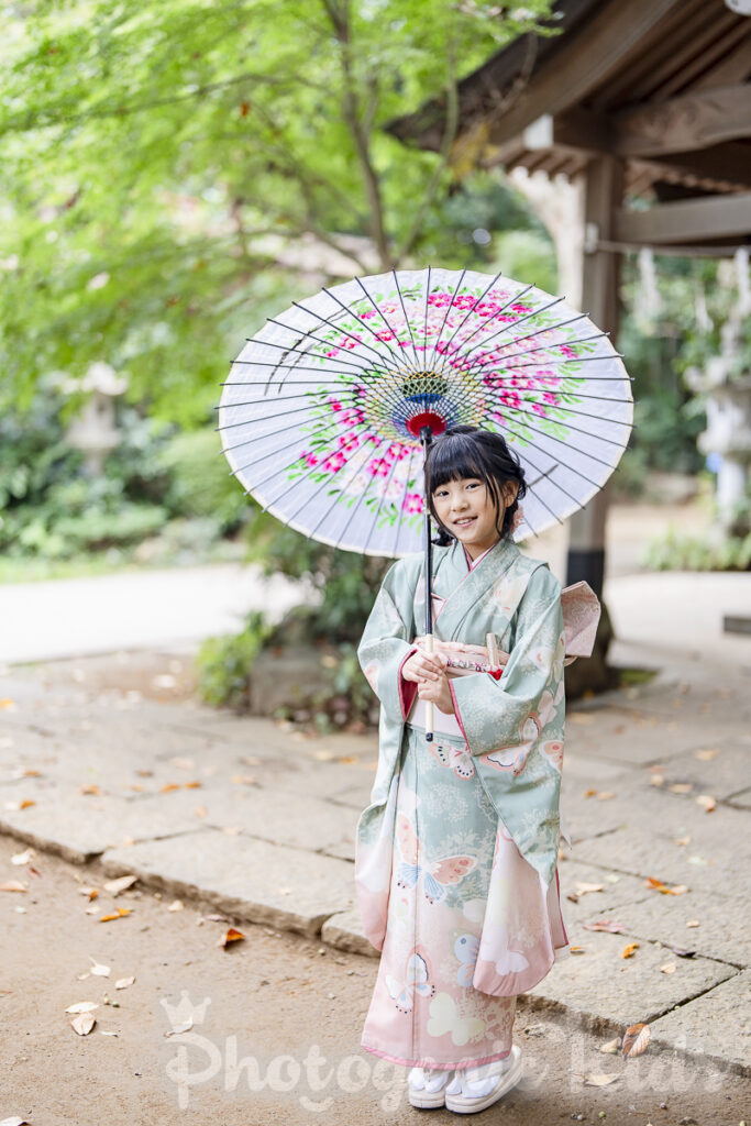 七五三のお祝いで七歳の女の子が美しい和傘を持つ写真