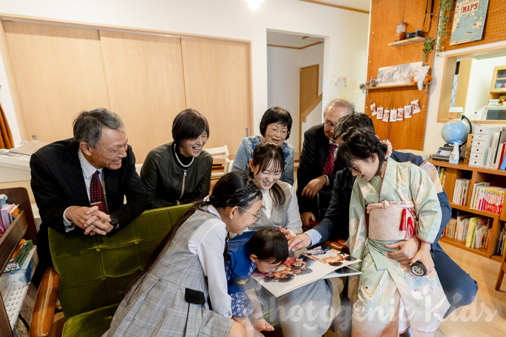 七五三とお宮参りの思い出写真集を見つめるご家族