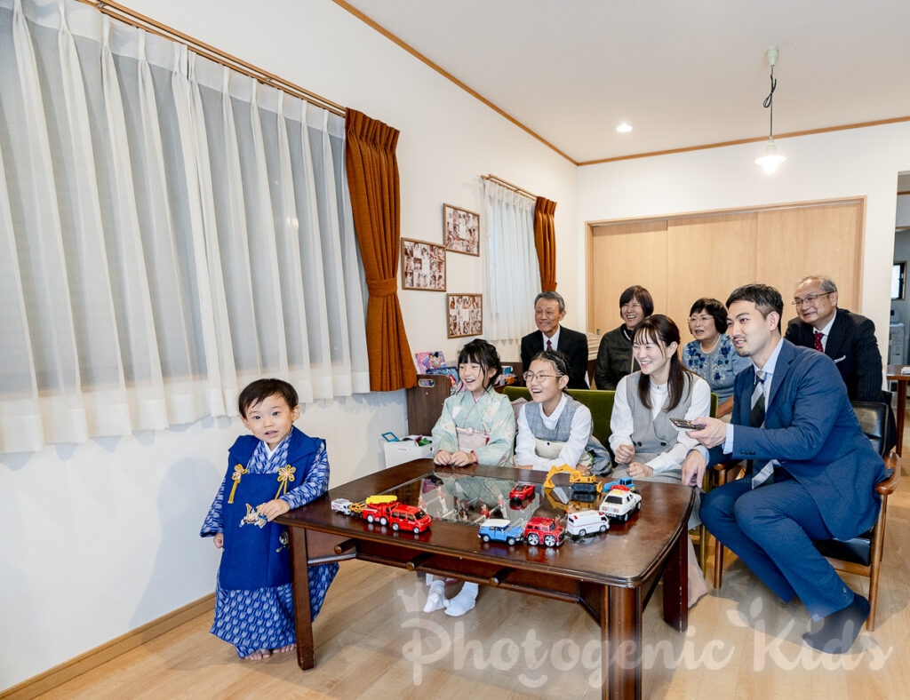 家族がリビングで七五三やお宮参りの動画を鑑賞しながら笑顔を見せる場面