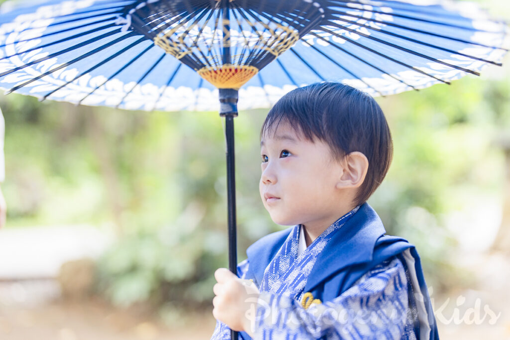 七五三で3歳の男の子が和傘を持ち希望に満ちた表情を見せる写真