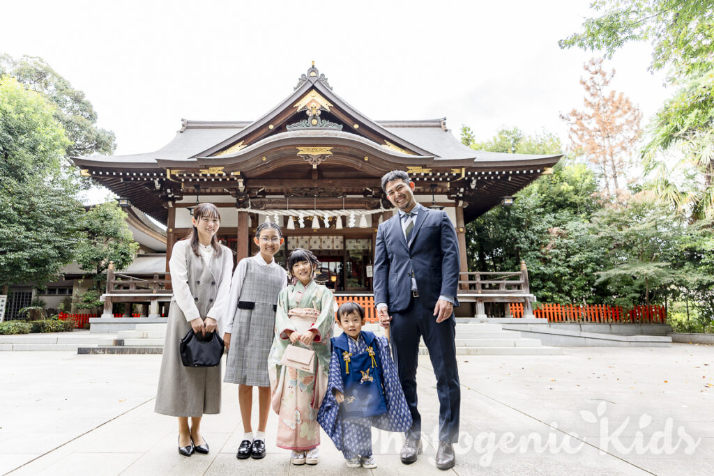 七五三の節目を祝う家族が本殿前で笑顔を交わす様子