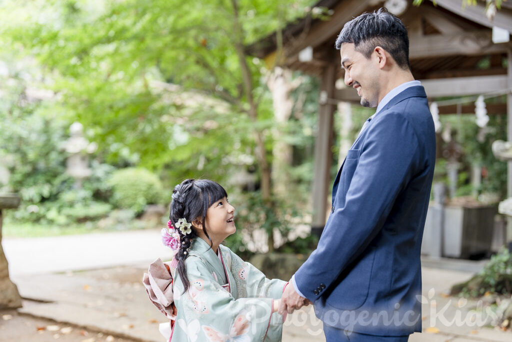七五三の着物で、パパと両手を繋ぎ見つめ合う女の子の自然な表情