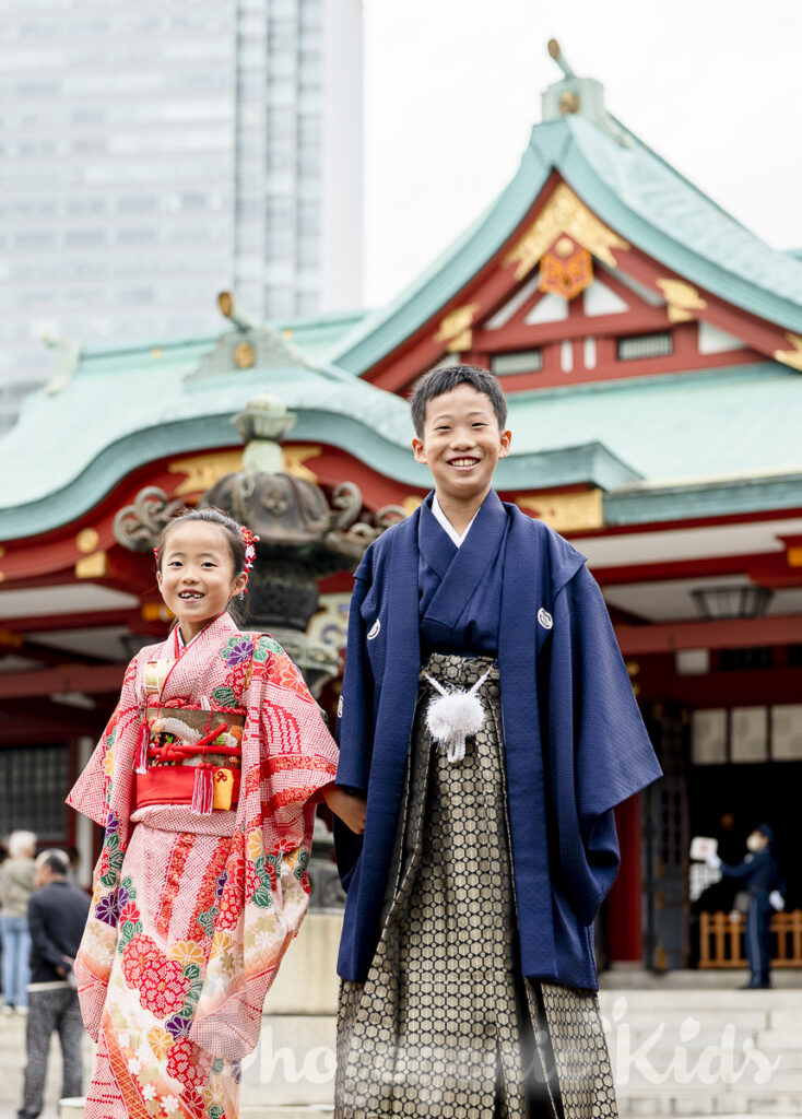 自然なやりとりの中で笑顔を見せる七五三の妹と1/2成人式のお兄ちゃんの写真
