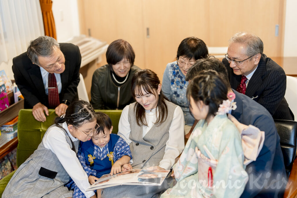 七五三とお宮参りの思い出写真集を見つめる3歳男の子