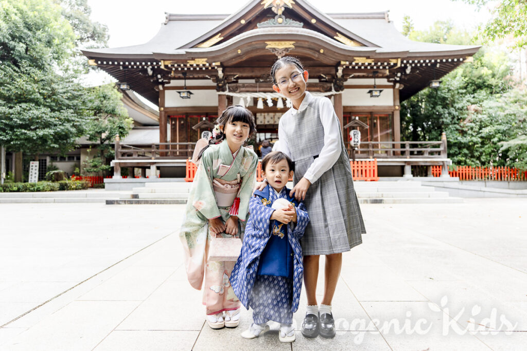 伝統的な七五三小物の鞠と三兄弟の和やかな家族写真