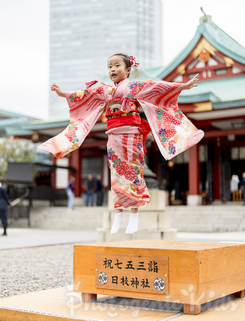 日枝神社の碁盤で元気にジャンプする七五三の女の子