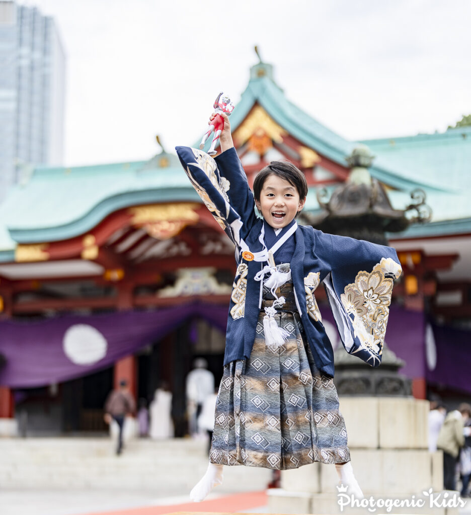 日枝神社でウルトラマンのポーズでジャンプする七五三男の子