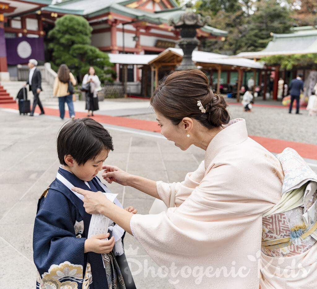 日枝神社の授与品メダルをママにかけてもらう五歳男の子