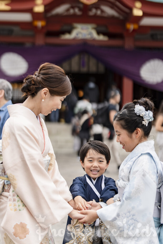 七五三と1/2成人式の兄弟が母と遊ぶ場面（日枝神社）