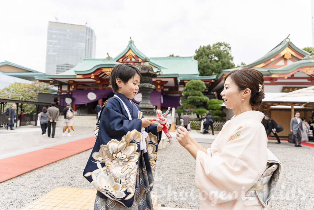 日枝神社で授与品のウルトラマンを持って遊ぶママと五歳男の子の写真